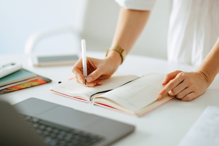 Close Up Photo Of Woman Hands Writing Notes In A Notebook At Work